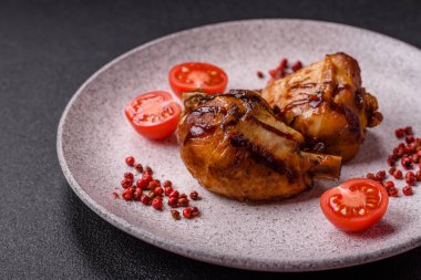 Lezzetli ızgara tavuk bacağı. Baharatlı ve otlu teriyaki soslu. Koyu beton arka planda.