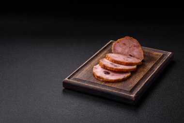 Koyu beton bir zeminde tütsülenmiş köfte veya tuzlu, baharatlı ve otlu sosis.