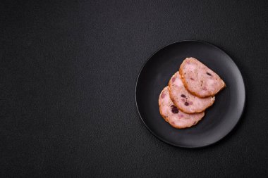 Koyu beton bir zeminde tütsülenmiş köfte veya tuzlu, baharatlı ve otlu sosis.