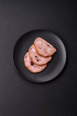 Koyu beton bir zeminde tütsülenmiş köfte veya tuzlu, baharatlı ve otlu sosis.