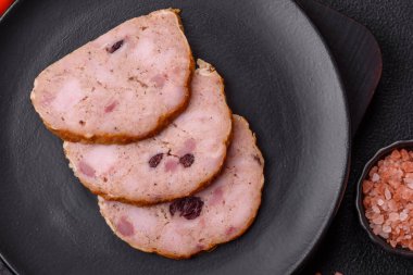 Koyu beton bir zeminde tütsülenmiş köfte veya tuzlu, baharatlı ve otlu sosis.