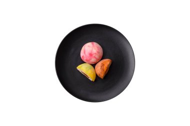 Lezzetli Asya mochi tatlısı pirinç hamuru kabuğu ve koyu beton arka planda meyveler.