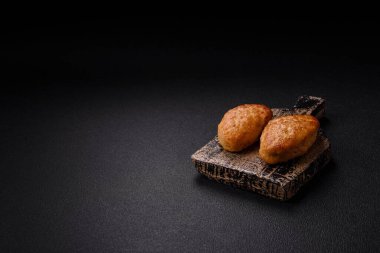 Lezzetli taze kıymalı balık pirzolası. Esmer arka planda baharatlar ve otlarla birlikte.