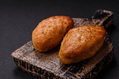 Lezzetli taze kıymalı balık pirzolası. Esmer arka planda baharatlar ve otlarla birlikte.