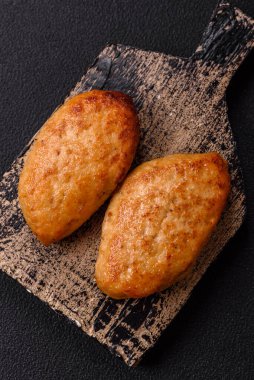 Lezzetli taze kıymalı balık pirzolası. Esmer arka planda baharatlar ve otlarla birlikte.