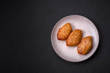 Lezzetli taze kıymalı balık pirzolası. Esmer arka planda baharatlar ve otlarla birlikte.