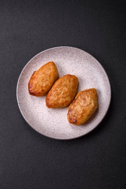 Lezzetli taze kıymalı balık pirzolası. Esmer arka planda baharatlar ve otlarla birlikte.