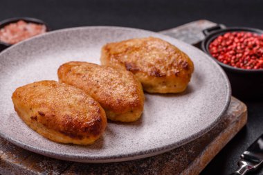 Lezzetli taze kıymalı balık pirzolası. Esmer arka planda baharatlar ve otlarla birlikte.