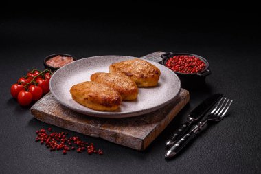 Lezzetli taze kıymalı balık pirzolası. Esmer arka planda baharatlar ve otlarla birlikte.