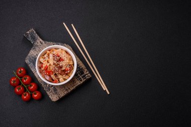 Sebzeli, etli, tuzlu ve baharatlı nefis Asya udonu tabağı koyu beton arka planda seramik bir tabakta.