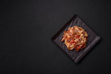 Sebzeli, etli, tuzlu ve baharatlı nefis Asya udonu tabağı koyu beton arka planda seramik bir tabakta.