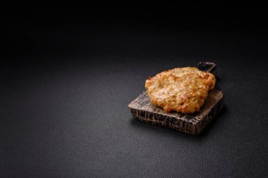 Lezzetli kızarmış domuz ya da koyu beton arka planda tuz ve baharatla ekilmiş tavuk pirzolası.