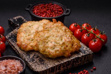 Lezzetli kızarmış domuz ya da koyu beton arka planda tuz ve baharatla ekilmiş tavuk pirzolası.