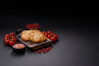 Lezzetli kızarmış domuz ya da koyu beton arka planda tuz ve baharatla ekilmiş tavuk pirzolası.