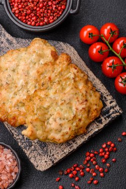 Lezzetli kızarmış domuz ya da koyu beton arka planda tuz ve baharatla ekilmiş tavuk pirzolası.