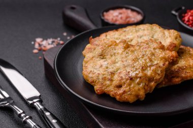 Lezzetli kızarmış domuz ya da koyu beton arka planda tuz ve baharatla ekilmiş tavuk pirzolası.