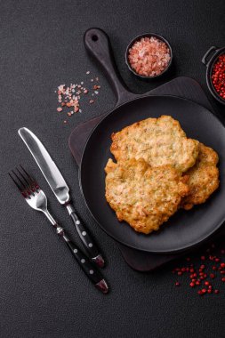 Lezzetli kızarmış domuz ya da koyu beton arka planda tuz ve baharatla ekilmiş tavuk pirzolası.