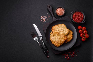 Lezzetli kızarmış domuz ya da koyu beton arka planda tuz ve baharatla ekilmiş tavuk pirzolası.