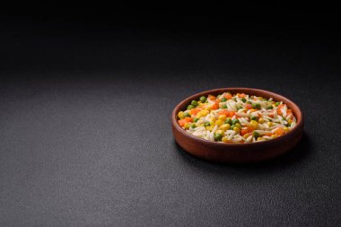 Lezzetli haşlanmış pirinç sebzeli veya havuçlu risotto, bezelye ve tuzlu ve baharatlı mısır.