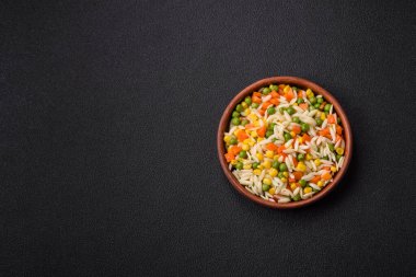 Lezzetli haşlanmış pirinç sebzeli veya havuçlu risotto, bezelye ve tuzlu ve baharatlı mısır.