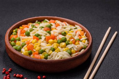 Lezzetli haşlanmış pirinç sebzeli veya havuçlu risotto, bezelye ve tuzlu ve baharatlı mısır.