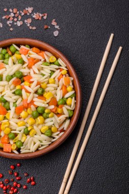 Lezzetli haşlanmış pirinç sebzeli veya havuçlu risotto, bezelye ve tuzlu ve baharatlı mısır.