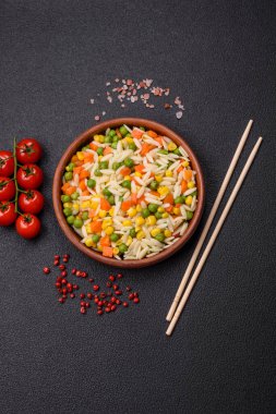 Lezzetli haşlanmış pirinç sebzeli veya havuçlu risotto, bezelye ve tuzlu ve baharatlı mısır.