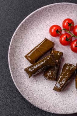 Pirinç şeklinde lezzetli dolma ve üzüm yapraklarına sarılmış et veya tuz ve baharatla değiştirilmiş et.