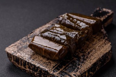 Pirinç şeklinde lezzetli dolma ve üzüm yapraklarına sarılmış et veya tuz ve baharatla değiştirilmiş et.