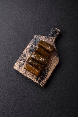 Pirinç şeklinde lezzetli dolma ve üzüm yapraklarına sarılmış et veya tuz ve baharatla değiştirilmiş et.