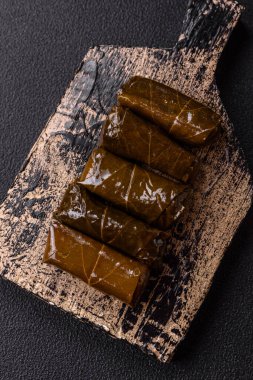 Pirinç şeklinde lezzetli dolma ve üzüm yapraklarına sarılmış et veya tuz ve baharatla değiştirilmiş et.