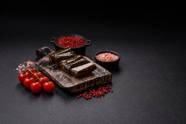 Pirinç şeklinde lezzetli dolma ve üzüm yapraklarına sarılmış et veya tuz ve baharatla değiştirilmiş et.