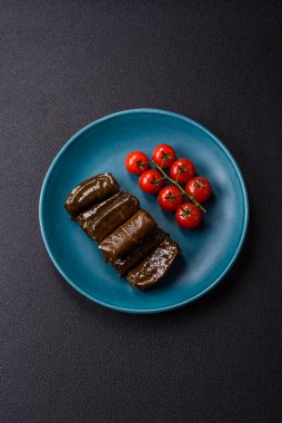 Pirinç şeklinde lezzetli dolma ve üzüm yapraklarına sarılmış et veya tuz ve baharatla değiştirilmiş et.