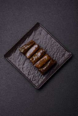 Pirinç şeklinde lezzetli dolma ve üzüm yapraklarına sarılmış et veya tuz ve baharatla değiştirilmiş et.