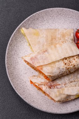 Lezzetli sulu rulo ya da tavuklu shawarma, domates, salata ve soslu koyu beton arka planda