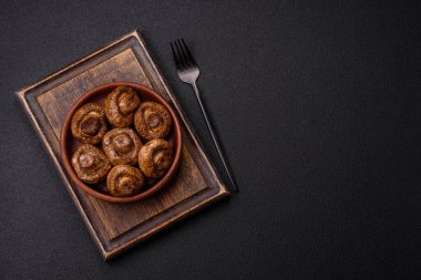 Izgarada pişirilmiş lezzetli sulu şampiyonlar koyu beton arka planda seramik tabakta tuz ve baharatlarla.