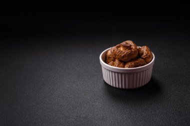 Izgarada pişirilmiş lezzetli sulu şampiyonlar koyu beton arka planda seramik tabakta tuz ve baharatlarla.