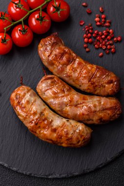 Koyu beton arka planda tuzlu, baharatlı ve otlu kızarmış domuz veya tavuk sosisi.