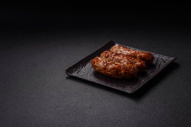 Koyu beton arka planda tuzlu, baharatlı ve otlu kızarmış domuz veya tavuk sosisi.