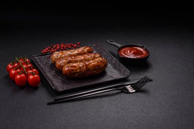 Koyu beton arka planda tuzlu, baharatlı ve otlu kızarmış domuz veya tavuk sosisi.