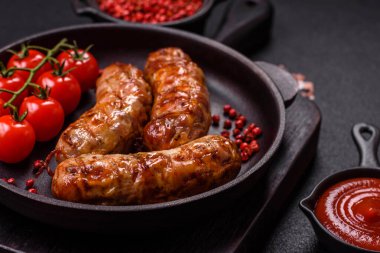 Koyu beton arka planda tuzlu, baharatlı ve otlu kızarmış domuz veya tavuk sosisi.