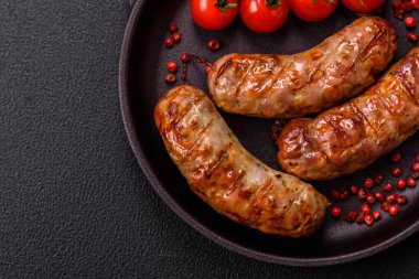 Koyu beton arka planda tuzlu, baharatlı ve otlu kızarmış domuz veya tavuk sosisi.