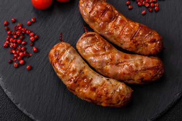 Koyu beton arka planda tuzlu, baharatlı ve otlu kızarmış domuz veya tavuk sosisi.