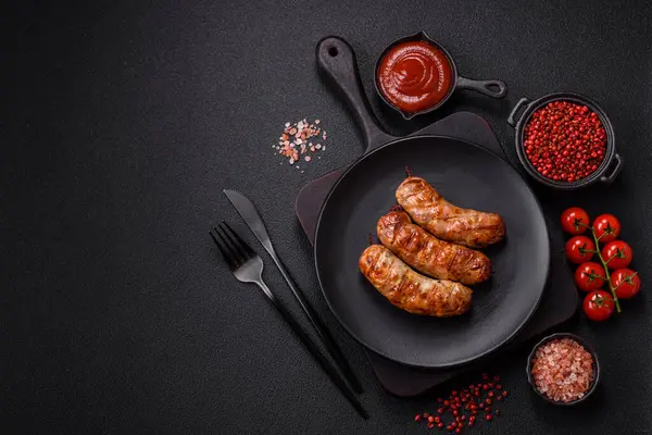 Koyu beton arka planda tuzlu, baharatlı ve otlu kızarmış domuz veya tavuk sosisi.