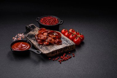 Tuz ve baharatla dilimlenmiş kızarmış sosisler koyu beton arka planda İngiliz kahvaltısı için bir malzeme.