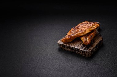 Lezzetli taze ızgara tavuk filetosu, esrarlı baharatlar ve çimento kaplı otlar. Ateşte pişirilmiş bir tabak.