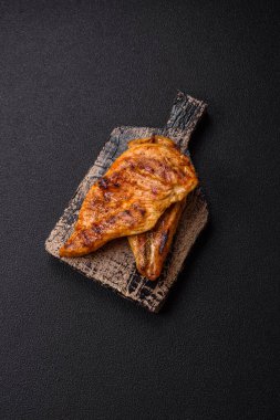 Lezzetli taze ızgara tavuk filetosu, esrarlı baharatlar ve çimento kaplı otlar. Ateşte pişirilmiş bir tabak.