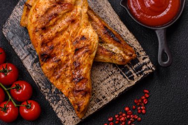 Lezzetli taze ızgara tavuk filetosu, esrarlı baharatlar ve çimento kaplı otlar. Ateşte pişirilmiş bir tabak.