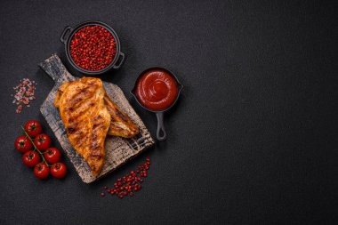 Lezzetli taze ızgara tavuk filetosu, esrarlı baharatlar ve çimento kaplı otlar. Ateşte pişirilmiş bir tabak.