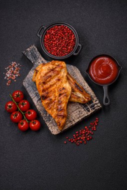 Lezzetli taze ızgara tavuk filetosu, esrarlı baharatlar ve çimento kaplı otlar. Ateşte pişirilmiş bir tabak.